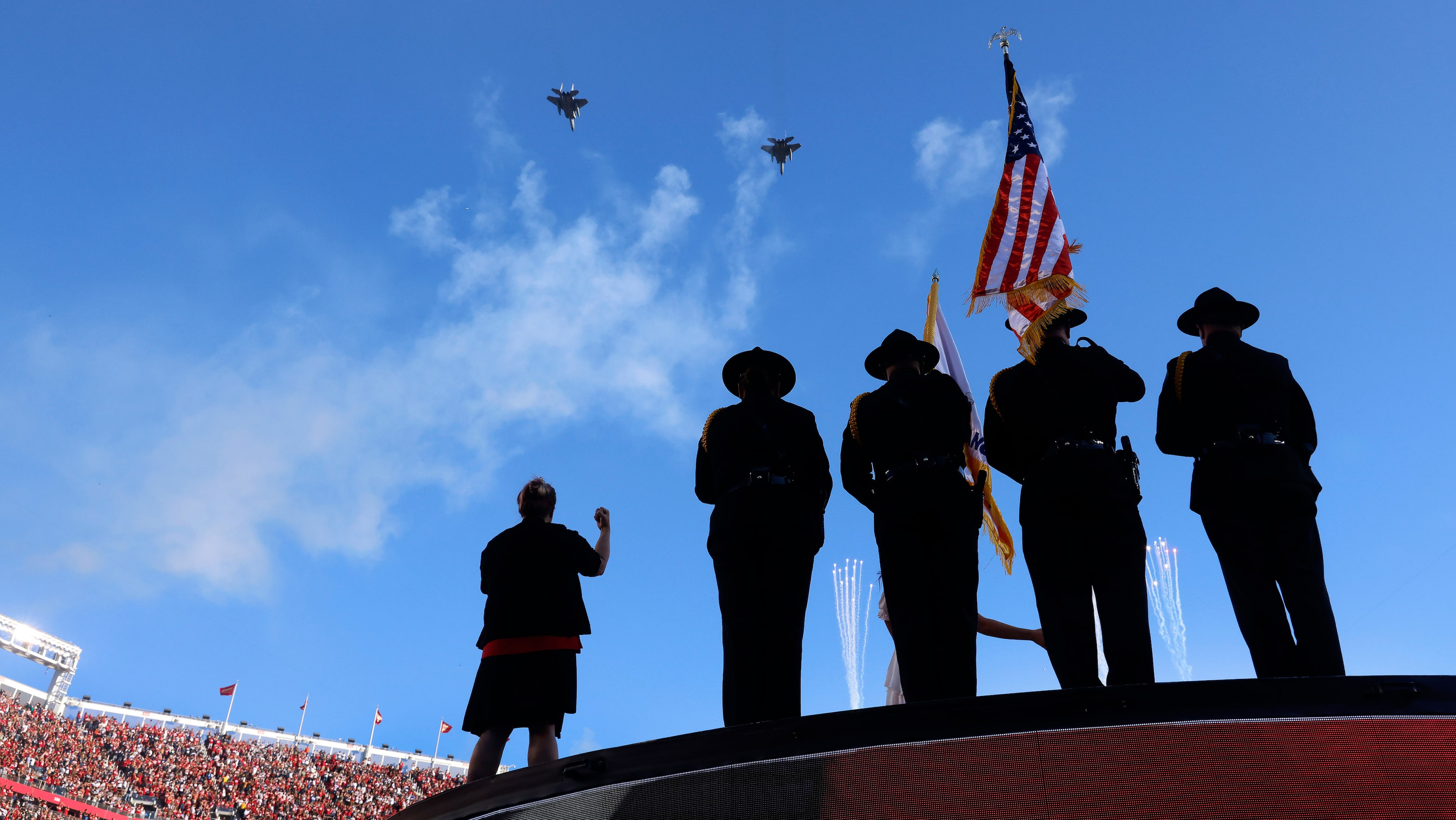 A pair of military aircraft perform a flyover during the national anthem before the Dallas...