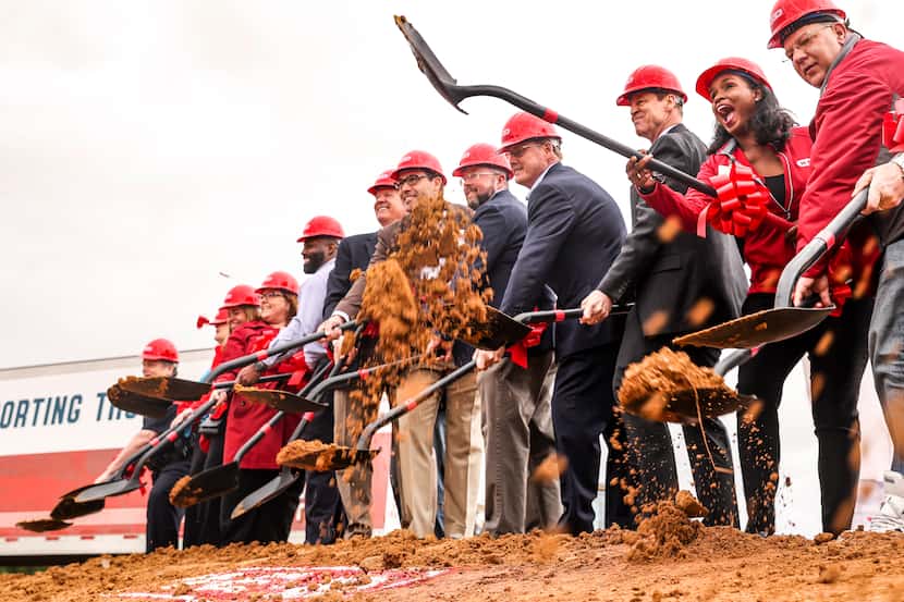 H-E-B executives shovel dirt at the groundbreaking of the Allen H-E-B store in 2022. The...
