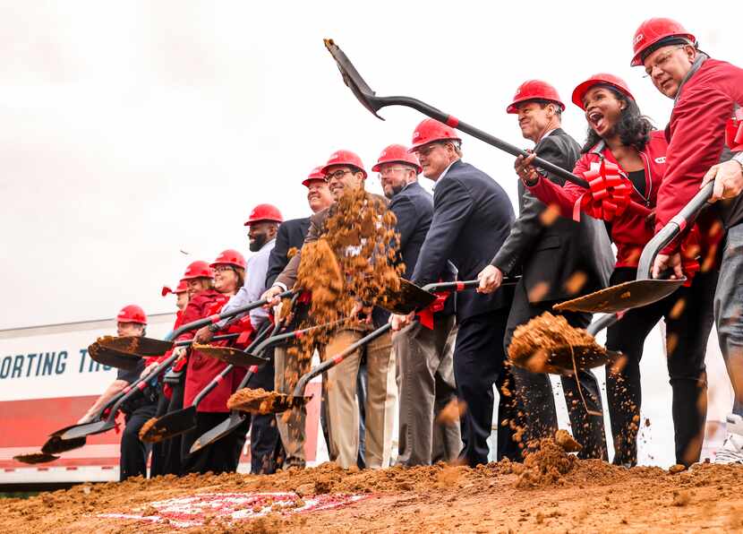 H-E-B Group Vice President Winell Herron raises her shovel as she and other employees shovel...