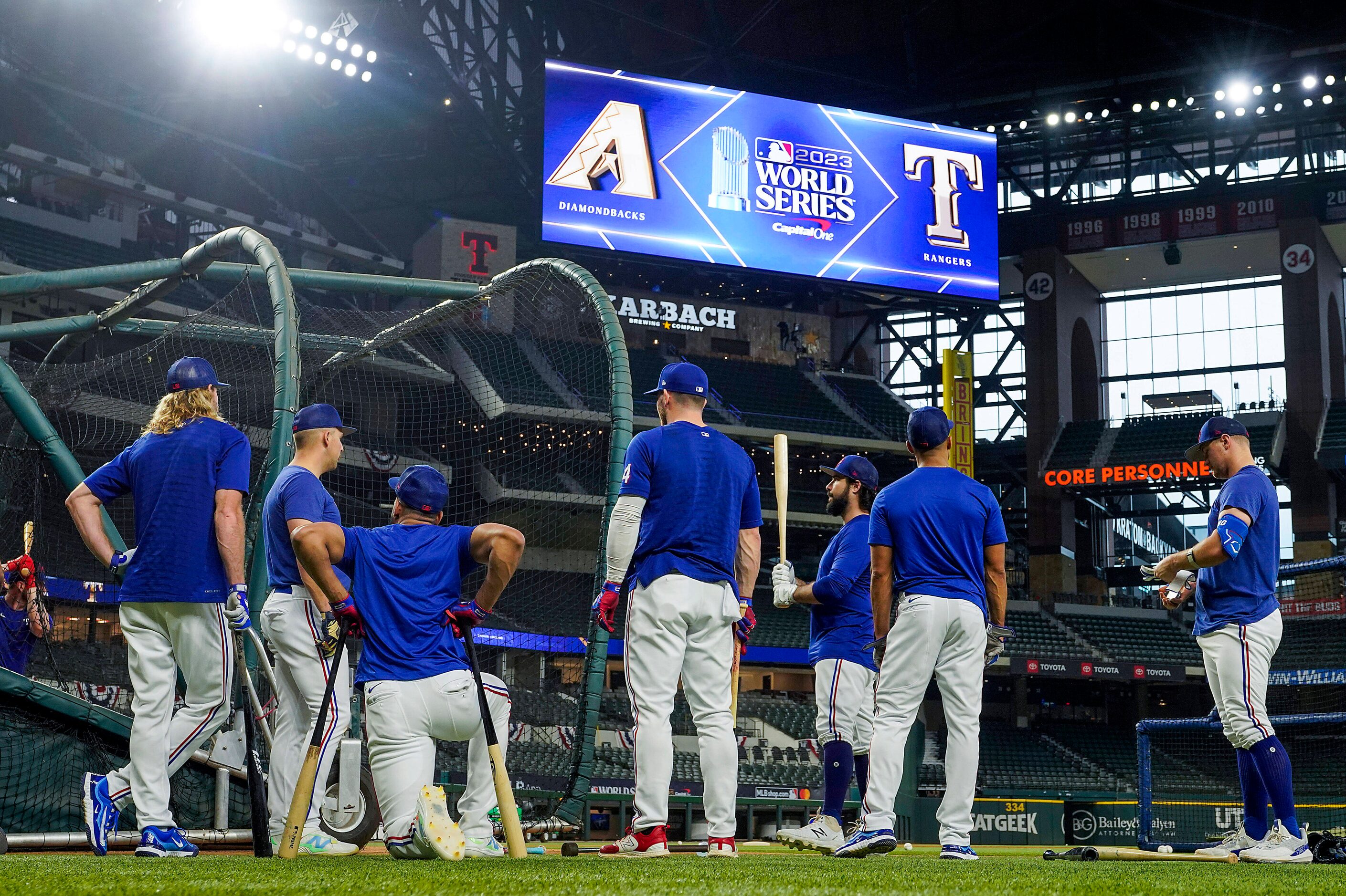 Texas Rangers players gather around the batting cage during a team workout at Globe Life...