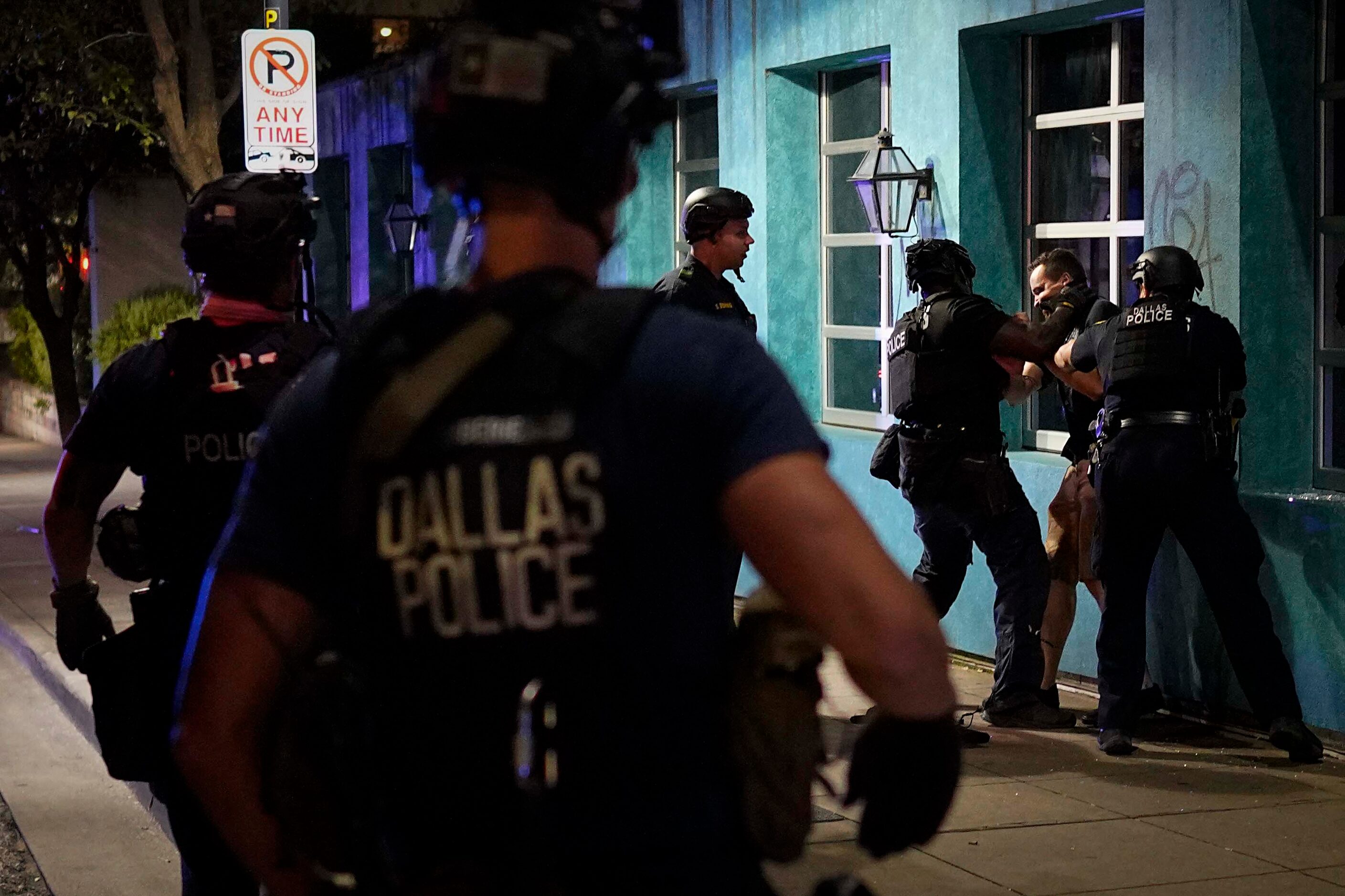 Dallas police arrest a man at Main Street and St. Paul as they go block by block working to...