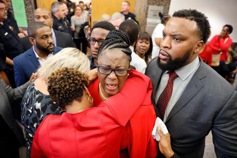 Botham Jean's mother, Allison Jean (center) is hugged by family members outside the 204th...