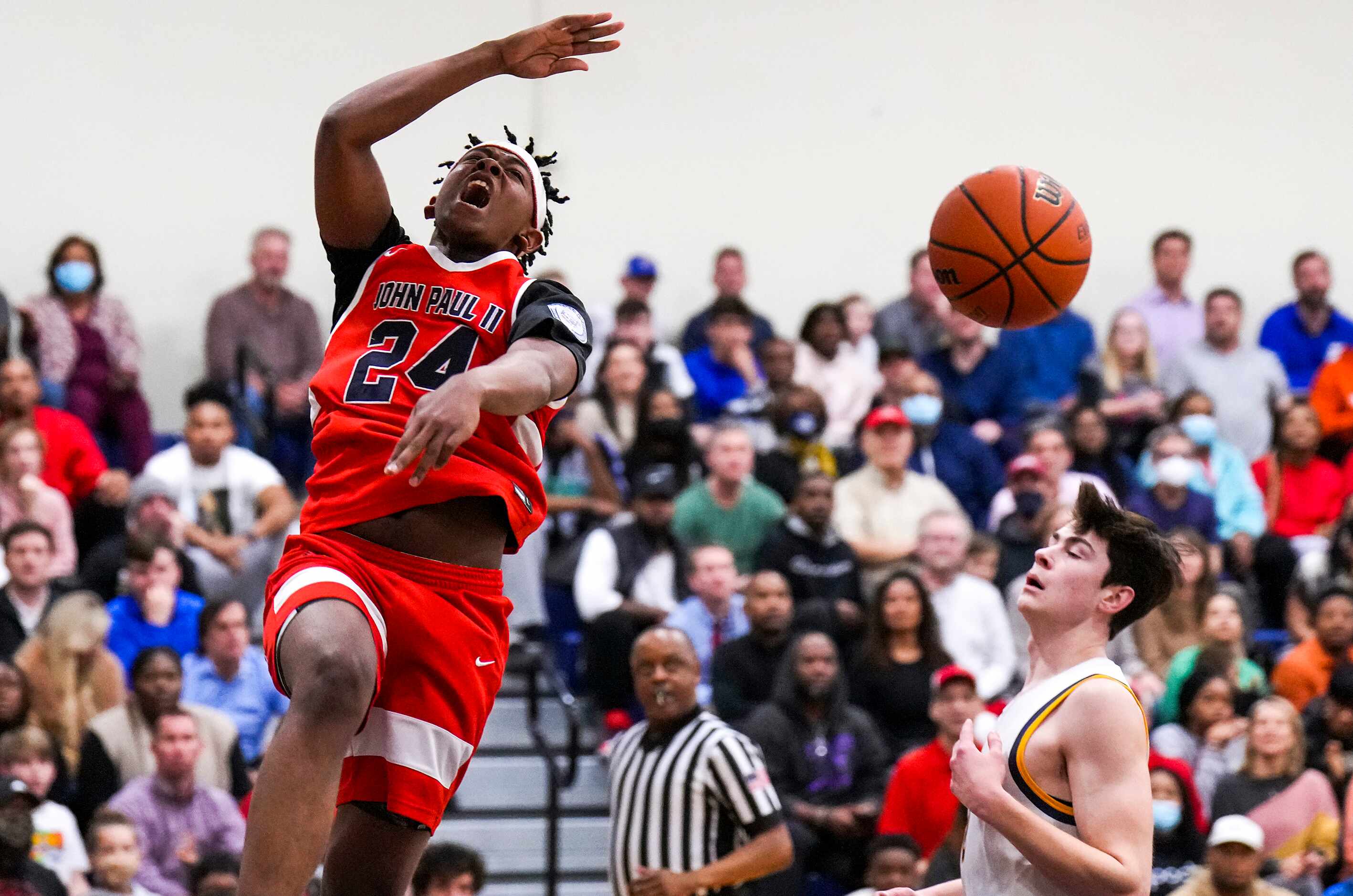 John Paul II's RJ Jones (24) follows through on a dunk past Prestonwood Christian's...