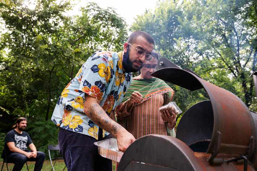 Usama Khalid mans a grill as he finishes cooking Seekh Kebabs and toasting nan during a...
