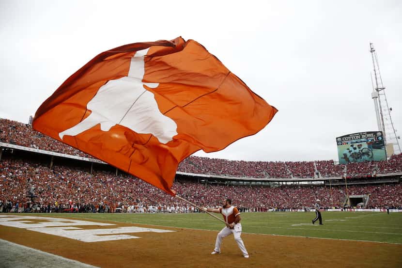 A Texas Longhorns cheerleader waves a Longhorn flag between action during an NCAA college...