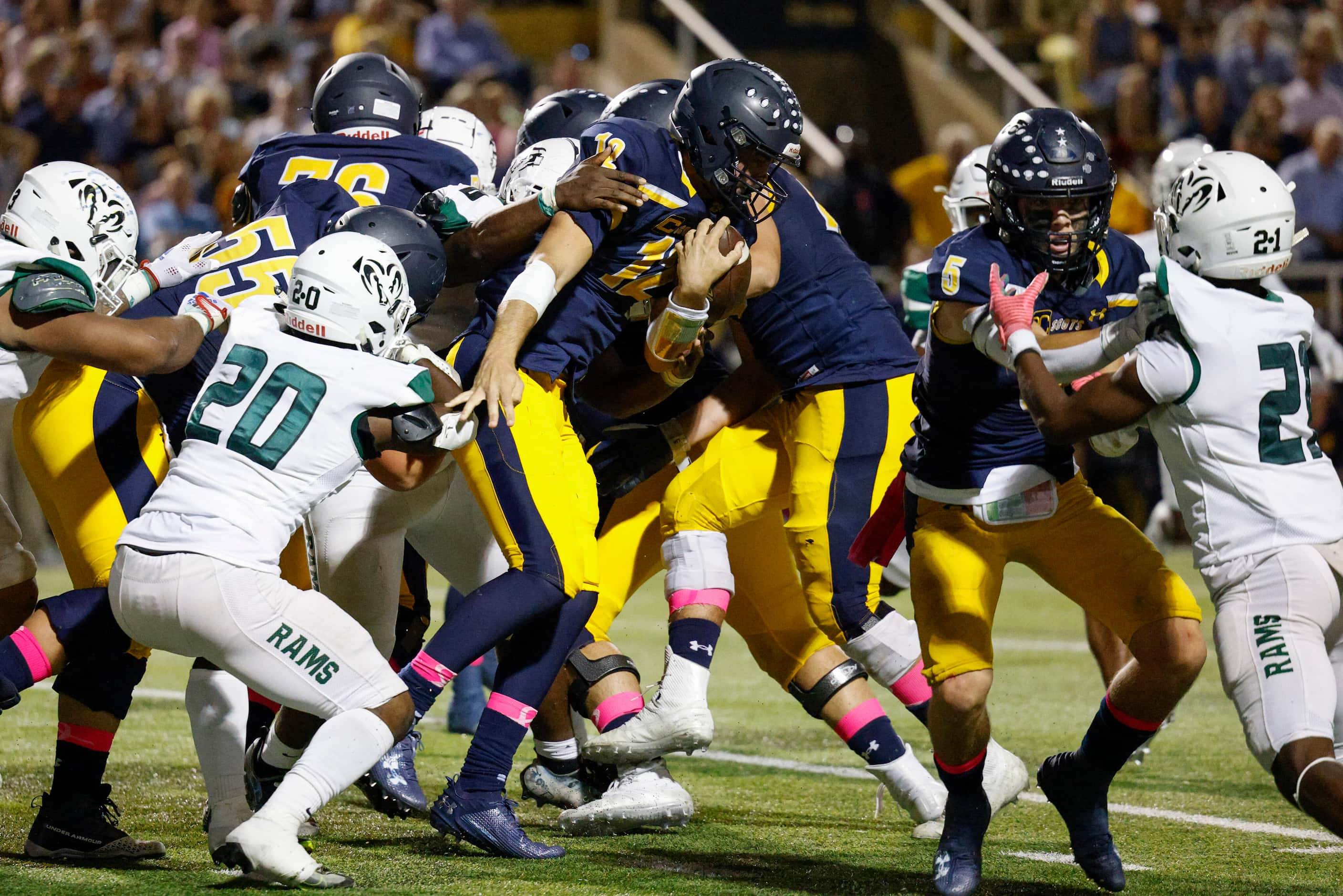 Highland Park quarterback Warren Peck (12) pushes through the line of scrimmage to pick up a...
