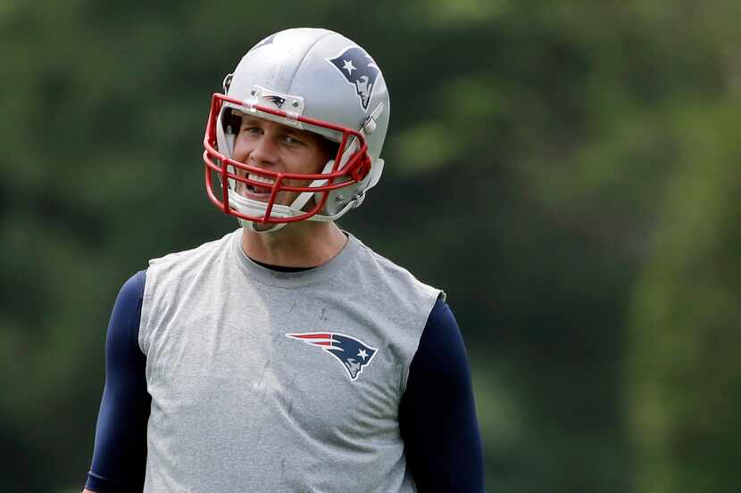New England Patriots quarterback Tom Brady laughs during an NFL organized team activity,...