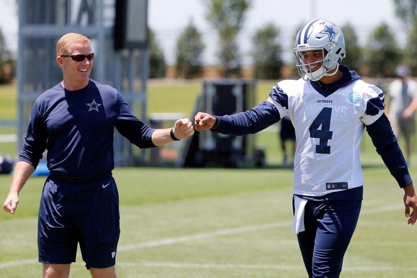 Dallas Cowboys head coach Jason Garrett, left, gets quarterback Dak Prescott (4) a fist bump...