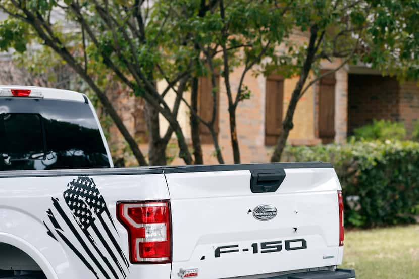 Bullet holes in the tailgate of a Ford F-150 pickup are pictured next door to the initial...