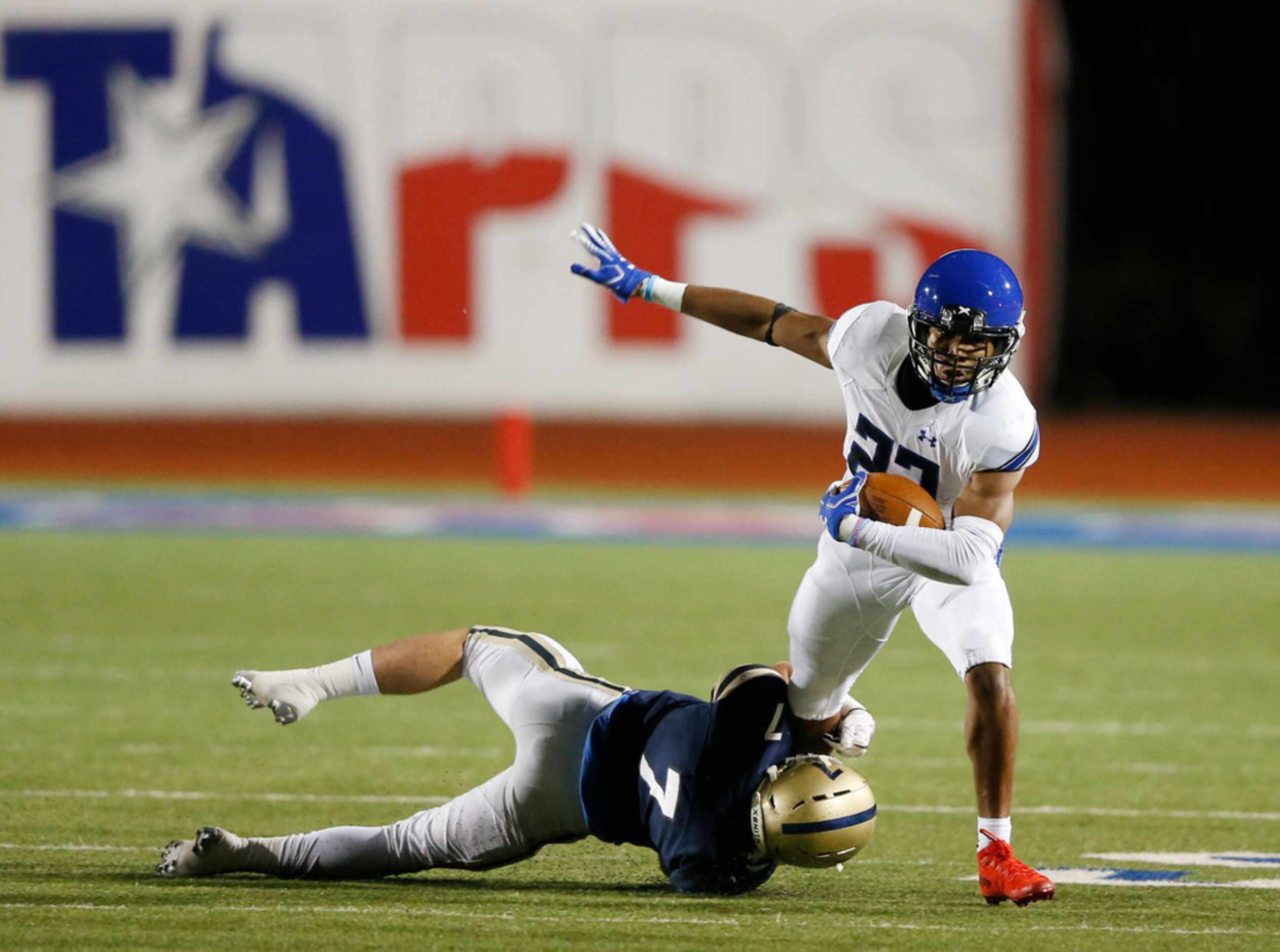 Trinity Christian's Desmond Moultrie (23) is tackled by Austin Regents William Raeder (7)...