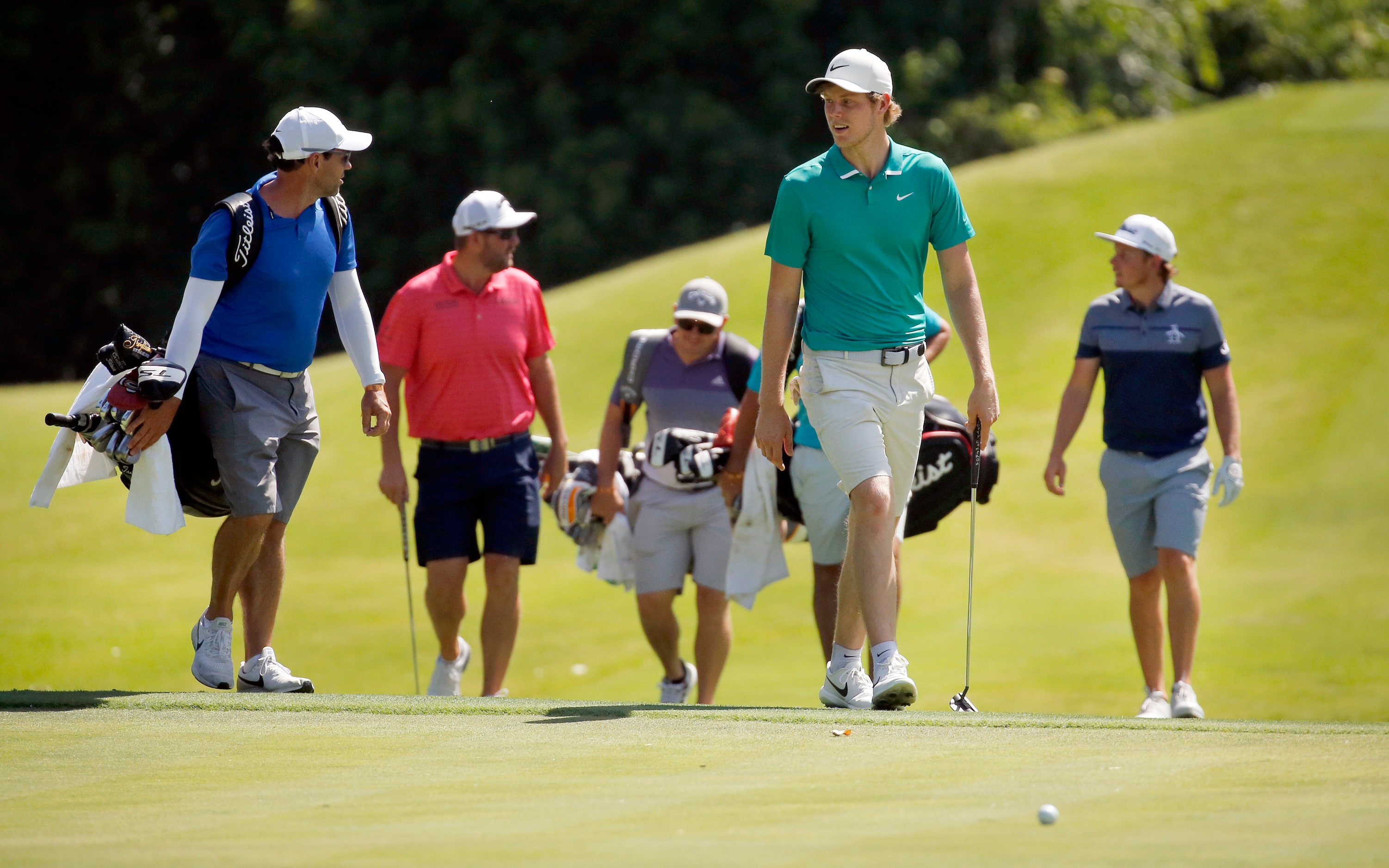 PGA golfer Cameron Davis (front, right) and his playing partners walk up to the No. 8 green...