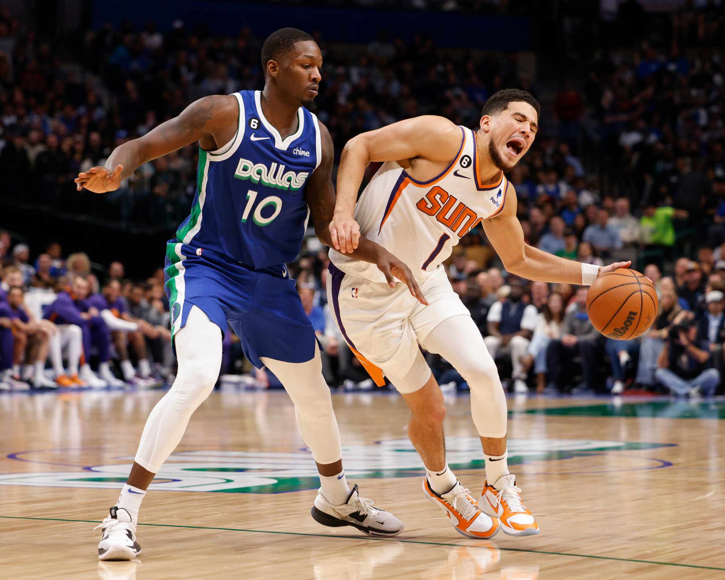 Phoenix Suns guard Devin Booker (1) collides with Dallas Mavericks forward Dorian...