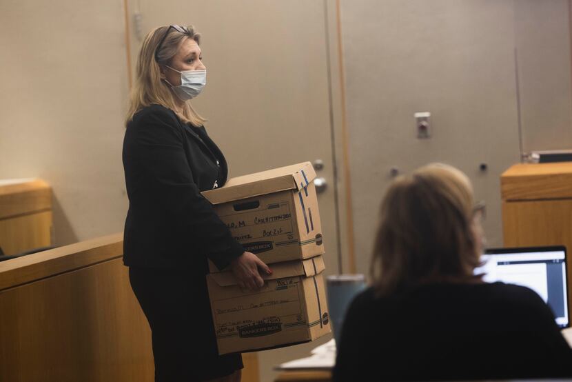 Prosecutor Robin Pittman carries boxes of case files from Dallas Police Department’s...