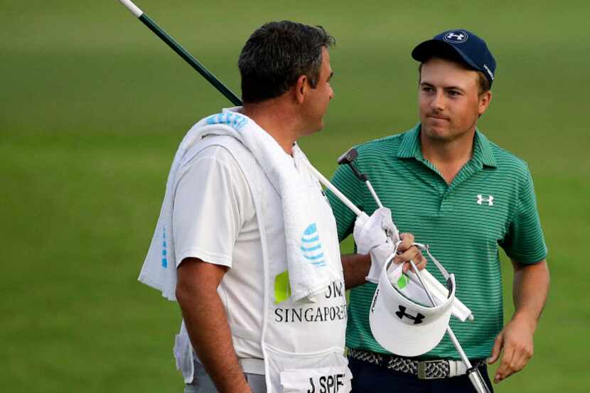 Jordan Spieth of the United States speaks with his caddy, Jay Danzi, left, during the final...