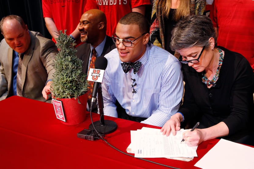 Solomon Thomas, third from left, is all smiles as his mother Martha Thomas, right, sign...