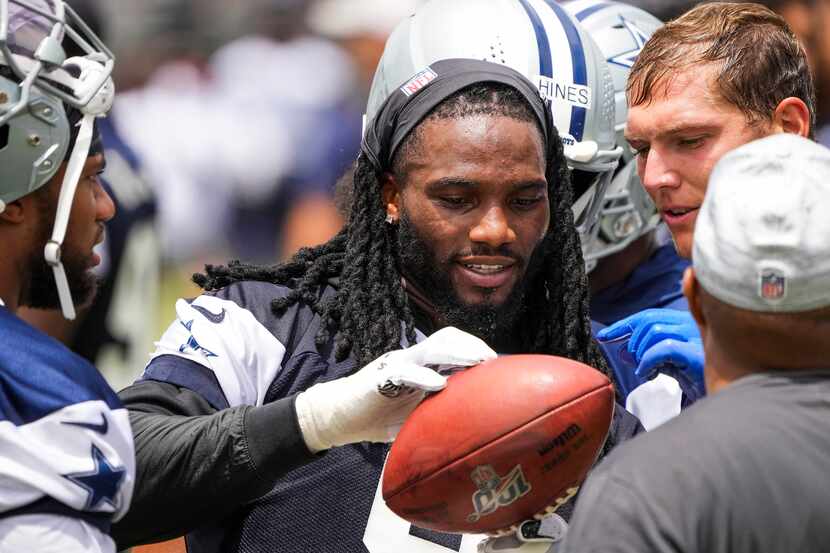 El apoyador de los Cowboys, Jaylon Smith, examina un balón con el apoyador Leighton Vander...