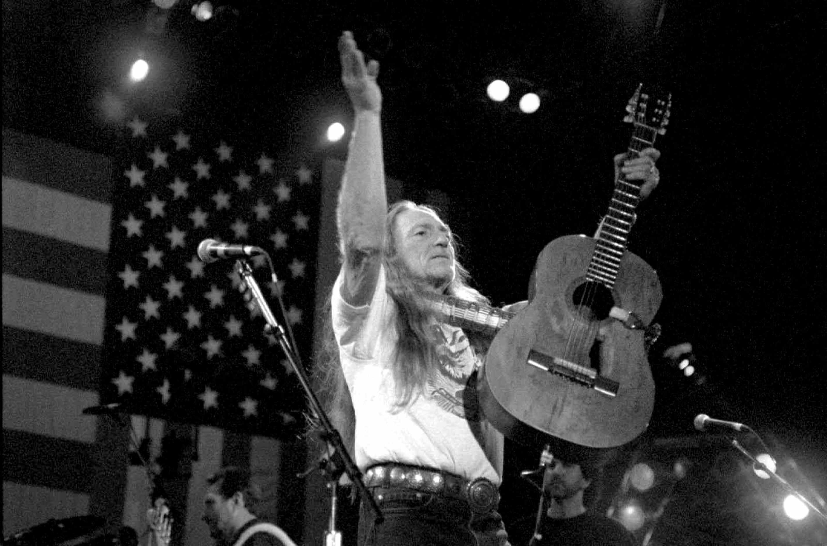 1994 - Willie Nelson brings the crowd to their feet during the Farm Aid VII concert in New...