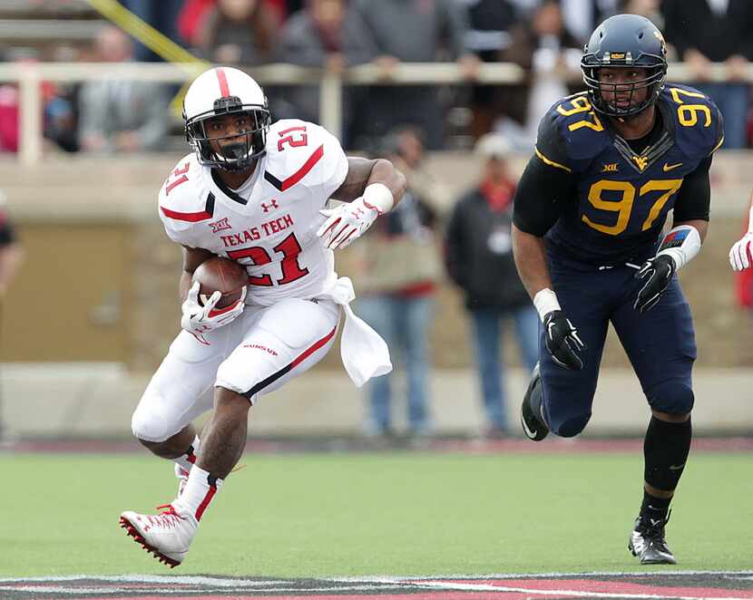 Texas Tech's DeAndre Washington runs past West Virginia's  Noble Nwachukwu during an NCAA...