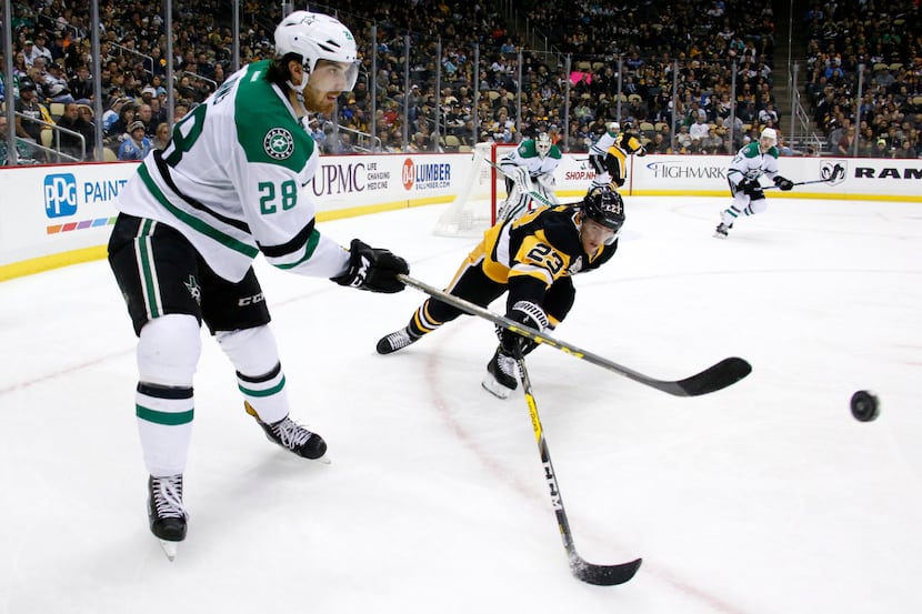 Dallas Stars' Stephen Johns (28) clears the puck before Pittsburgh Penguins' Scott Wilson...