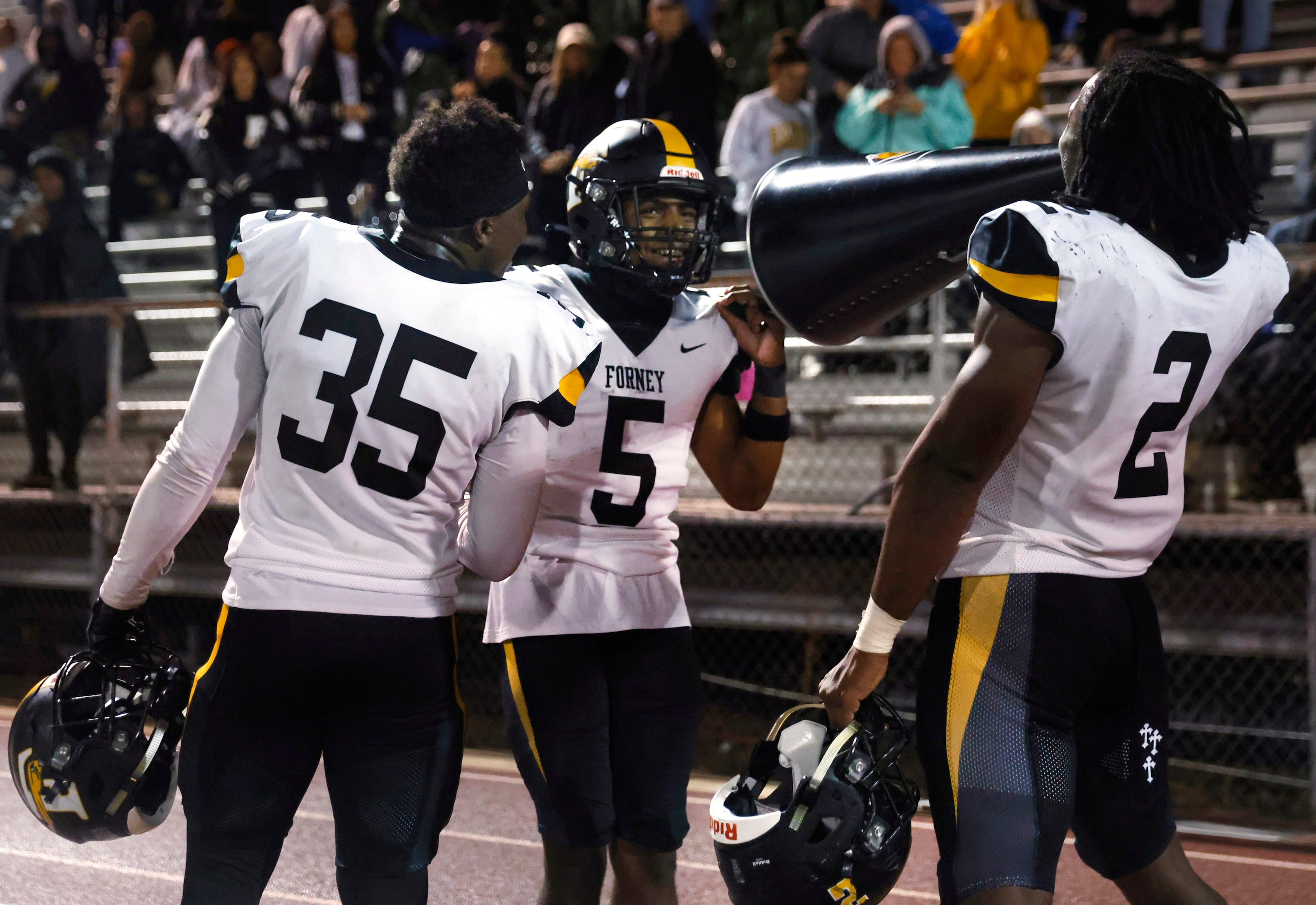 Forney’s Kelvion Riggins (right) uses a cheerleaders megaphone to congratulate Cadon Webb...