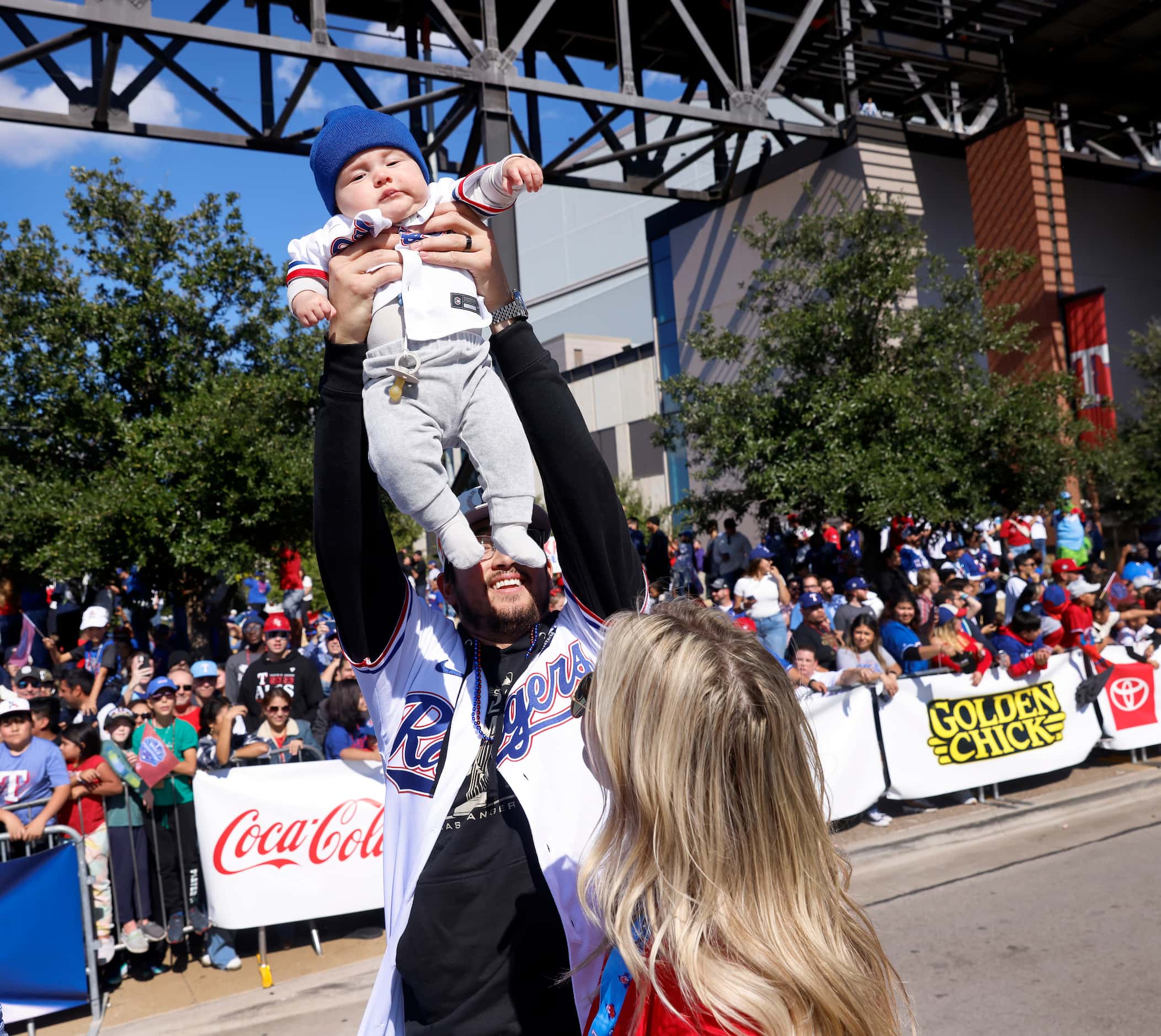 Texas Rangers pitcher Dane Dunning (33) raises his baby up to the crowd as he receives...