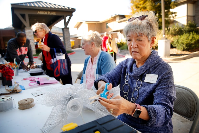 Resident Pam Altizer creates a holiday bow as she joins her friend Susan deLarios at an arts...