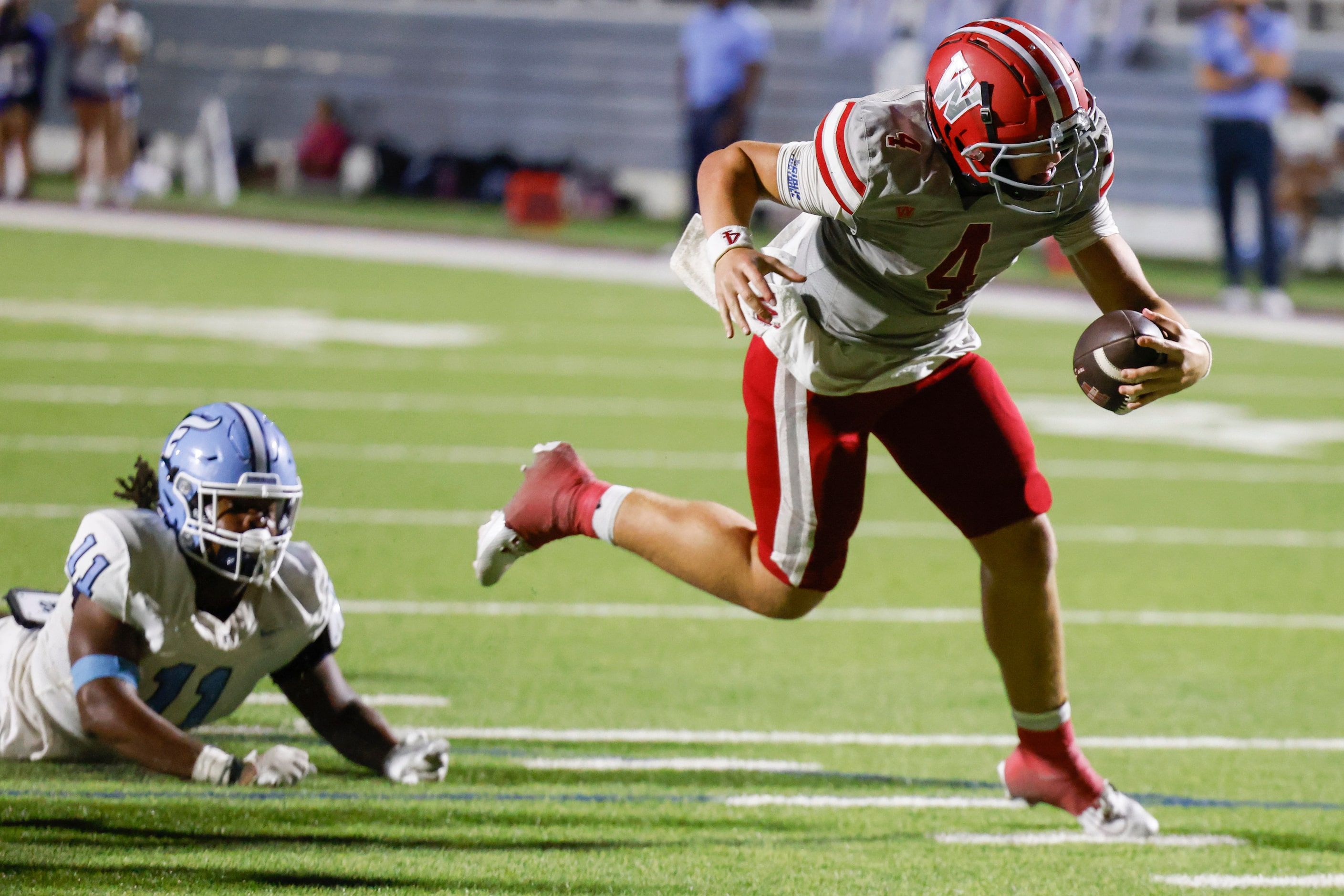 Emerson high’s Agape Lawrence (11) watches as Woodrow Wilson’s QB Cam McGuire carries a...