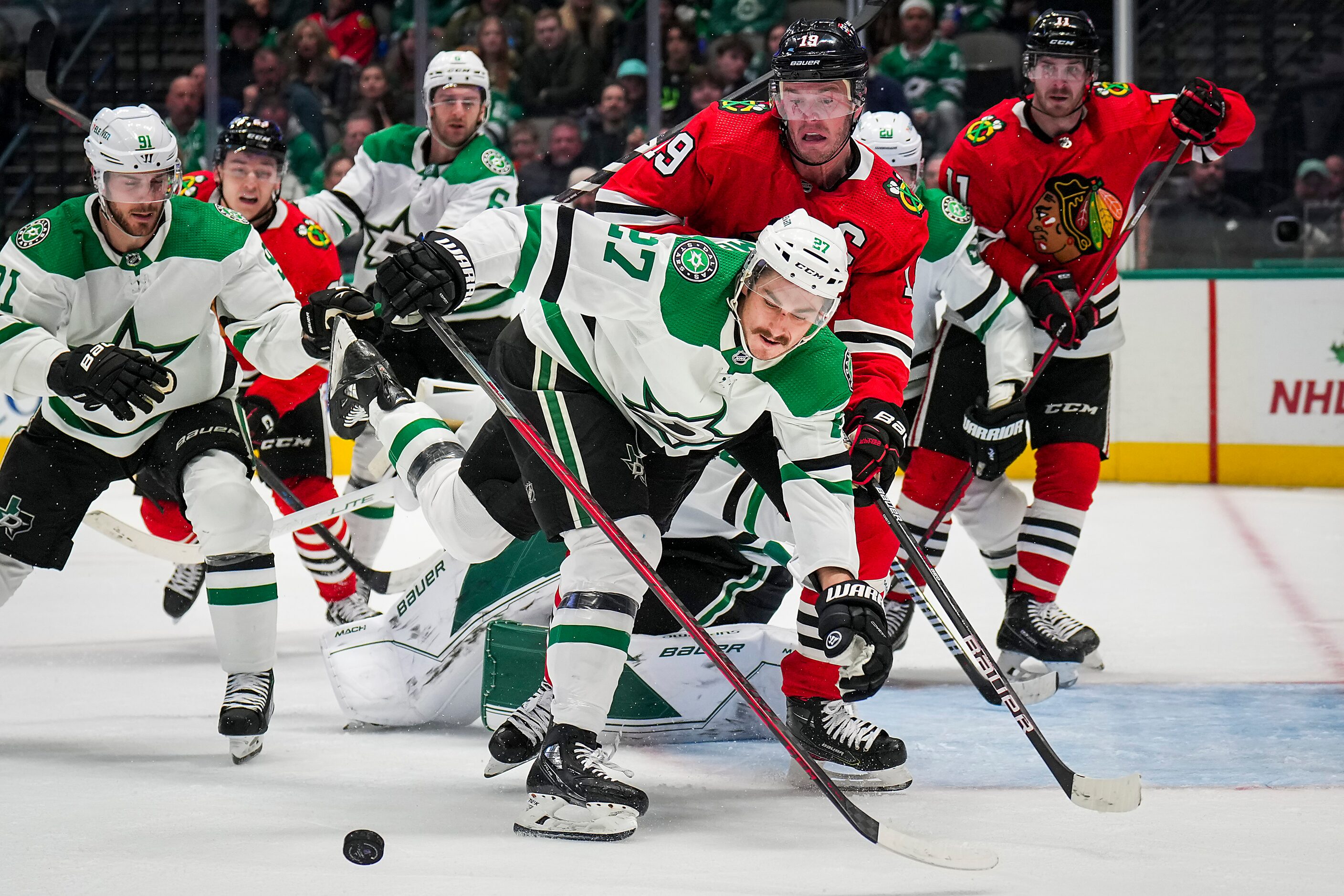 Dallas Stars left wing Mason Marchment (27) fights for the puck against Chicago Blackhawks...