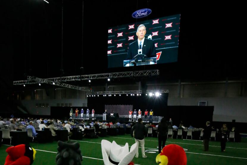 Mascots sit on the field while watching Big 12 commissioner Bob Bowlsby speaks to reporters...
