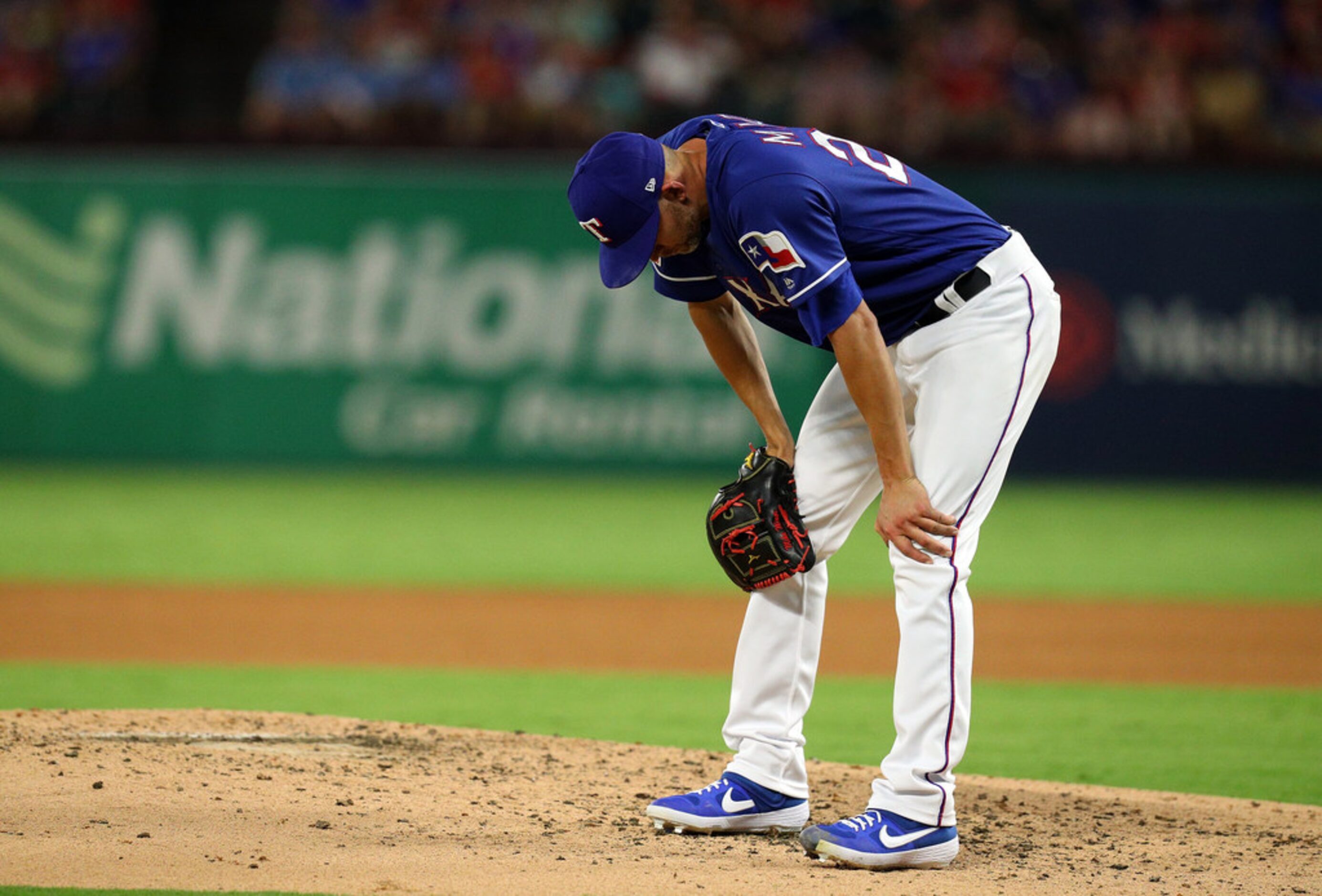 ARLINGTON, TEXAS - SEPTEMBER 14: Mike Minor #23 of the Texas Rangers reacts after giving up...