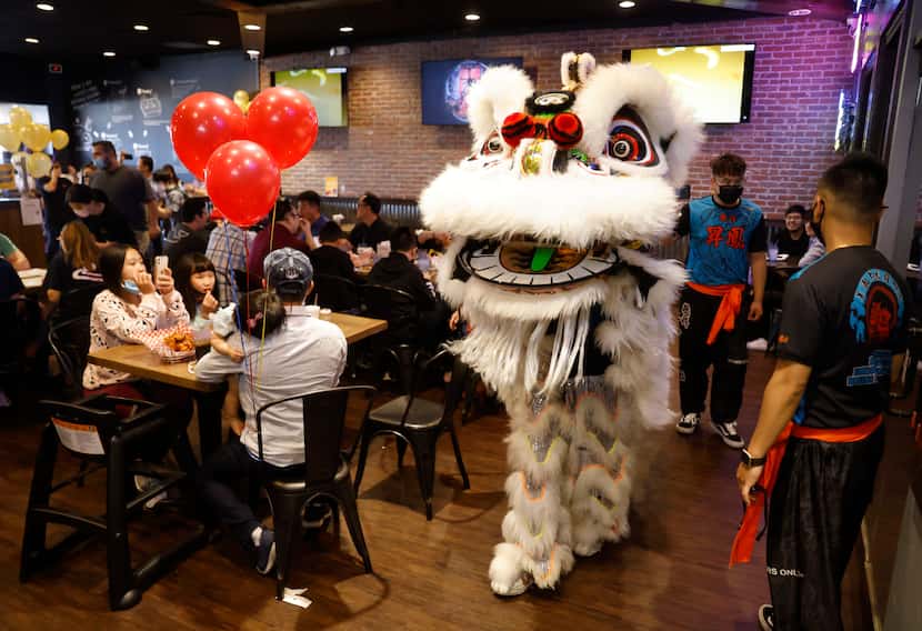Customers watch as costumed entertainers make their way through the dining area of BB.Q...