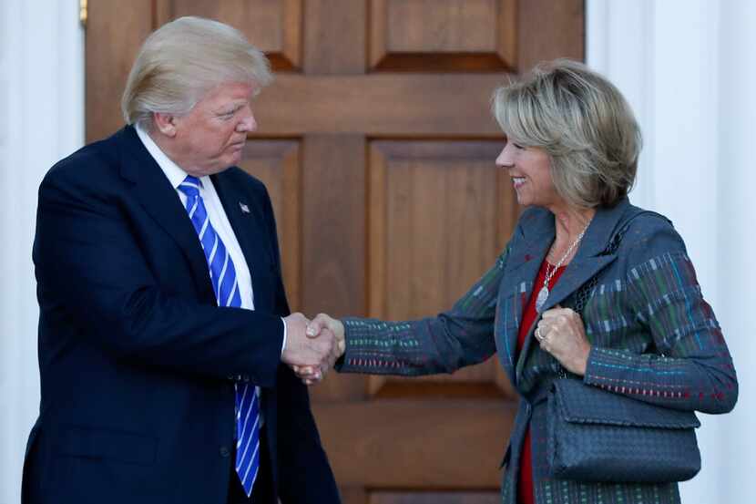 President-elect Donald Trump and Betsy DeVos shake hands at Trump National Golf Club...