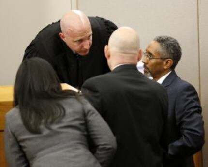  Attorneys huddle with state District Judge Brandon Birmingham in the murder trial of...