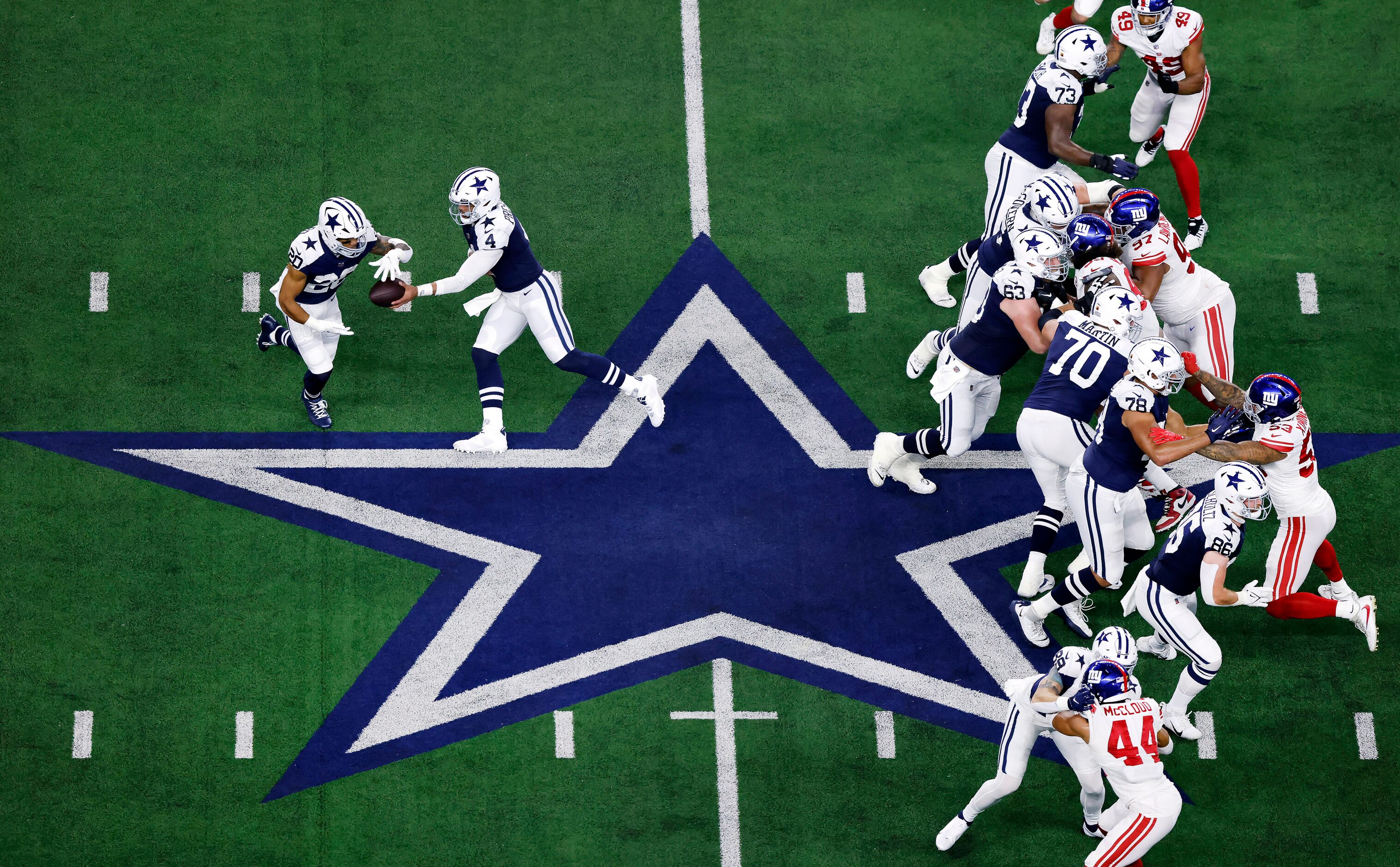 Dallas Cowboys running back Tony Pollard (20) takes the handoff from quarterback Dak...