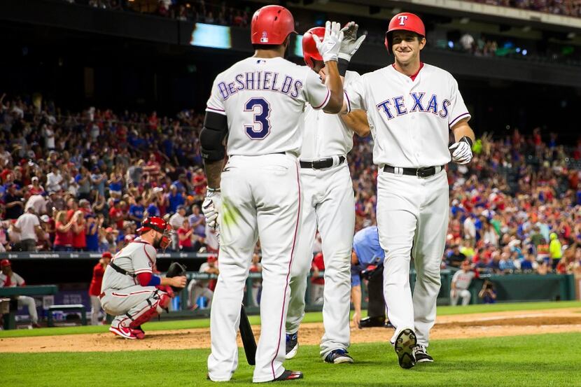 Texas Rangers center fielder Jared Hoying gets a hand from left fielder Delino DeShields...