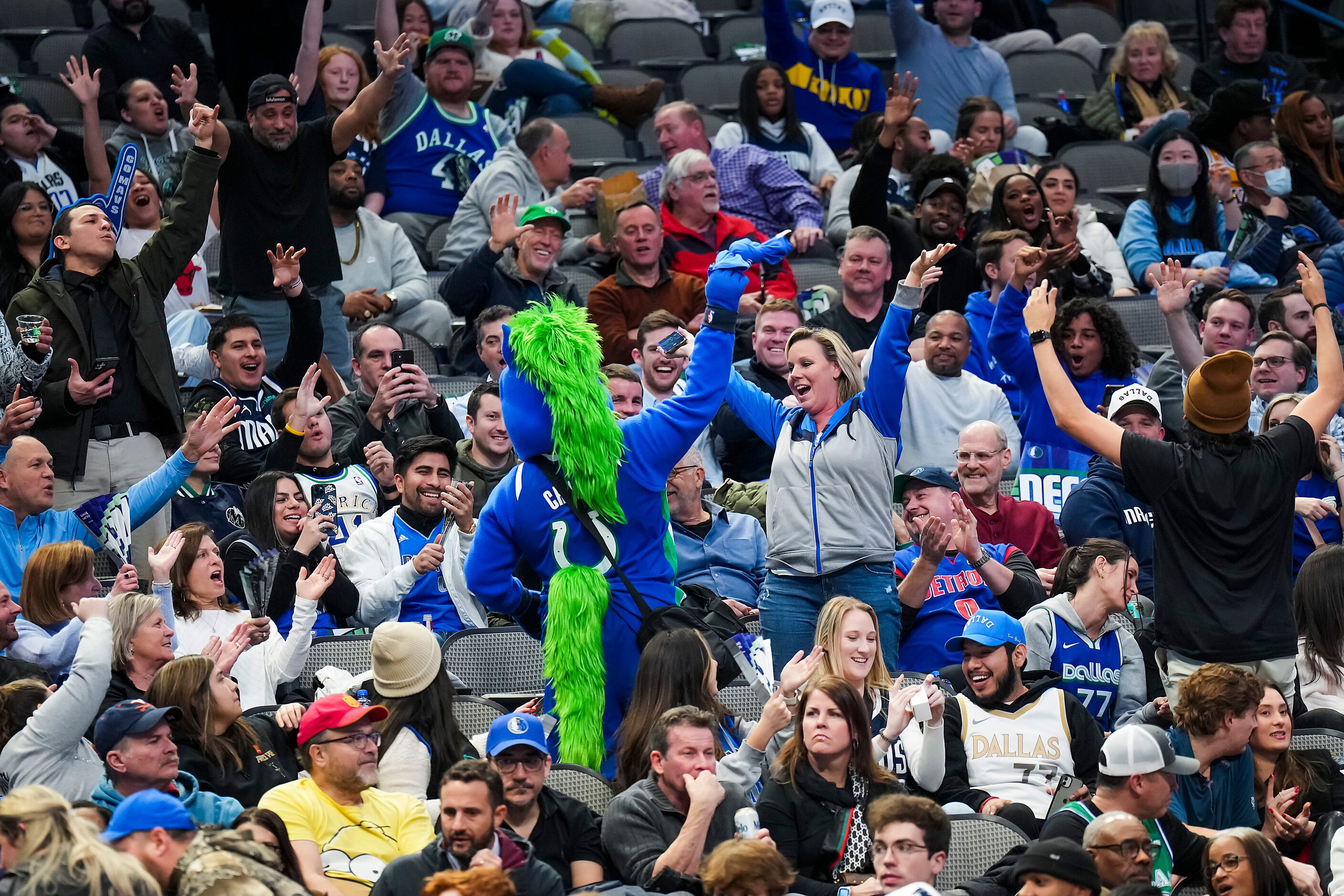 Dallas Mavericks fans cheer mascot Champ during the second half of an NBA basketball game...