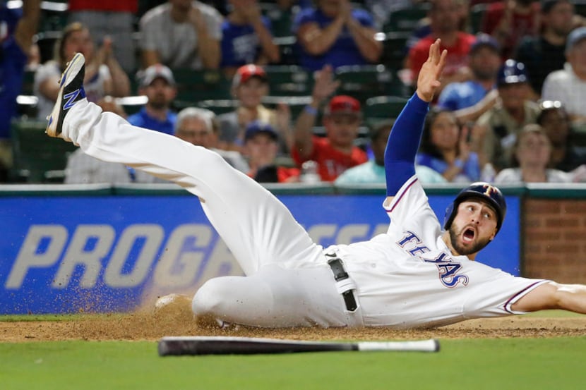 Texas Rangers third baseman Joey Gallo (13) slides into home safely in the eighth inning...