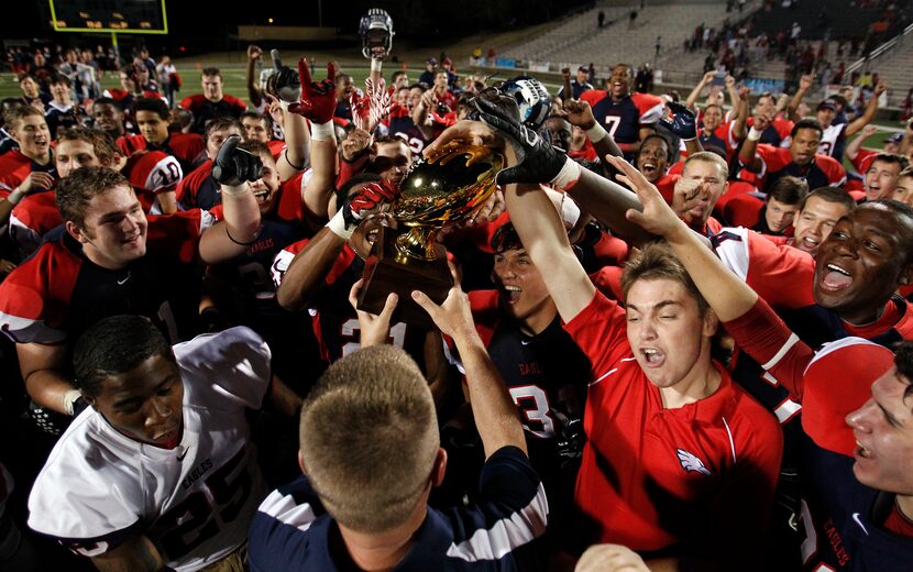 Allen's head coach Tom Westerberg hands the 5A Division 1 Region II Finals Champion trophy...