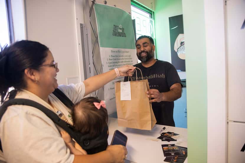 Kristen Soto carries 11-month-old Emeri as she grabs her Halal Fusionz’s, a Pakistani and...