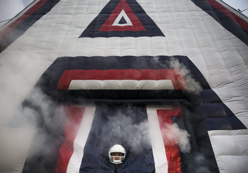 Allen kicker Michael Ewton (89) peaks out of a giant inflatable letter 'A' before entering...