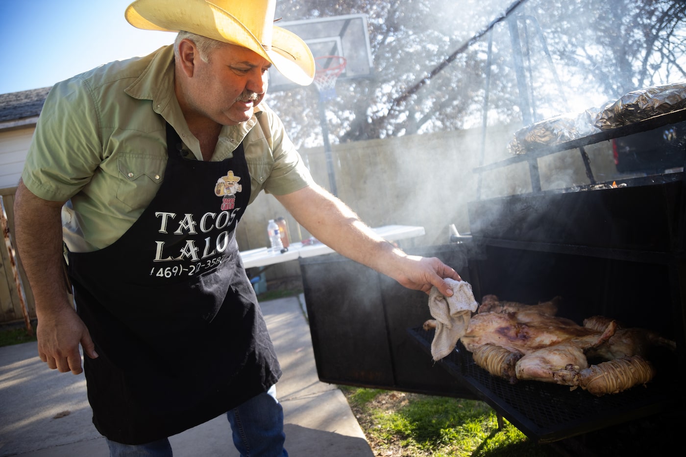 Eduardo Montemayor, a native of Monterrey and owner of Tacos Lalo, checks on the cabrito as...