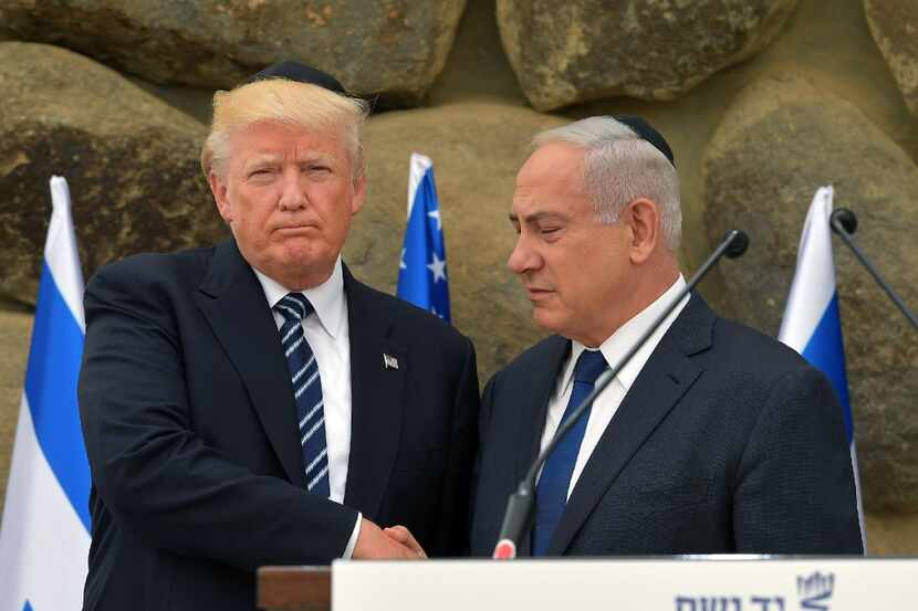 Israel's Prime Minister Benjamin Netanyahu (R) shakes hands with US President Donald Trump...