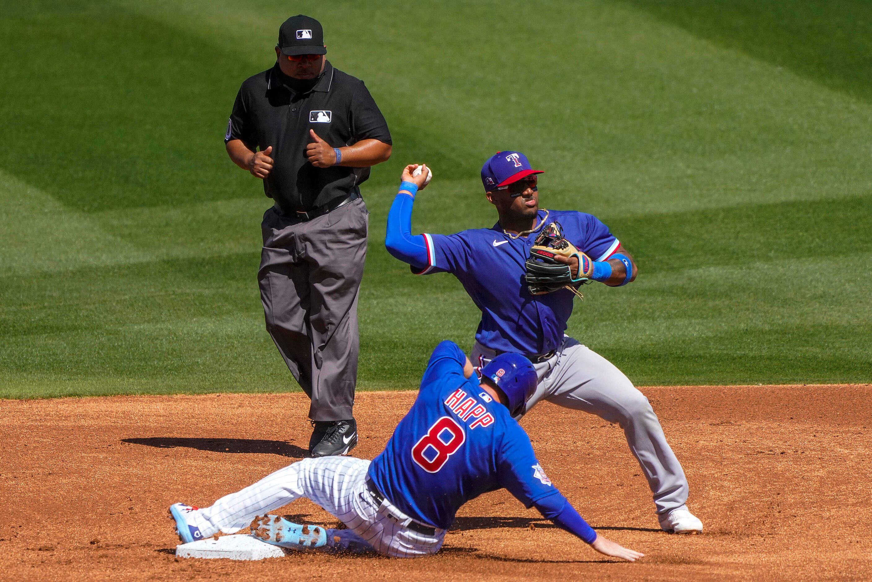 Texas Rangers infielder Andy Ibáñez makes a relay over Chicago Cubs center fielder Ian Happ...