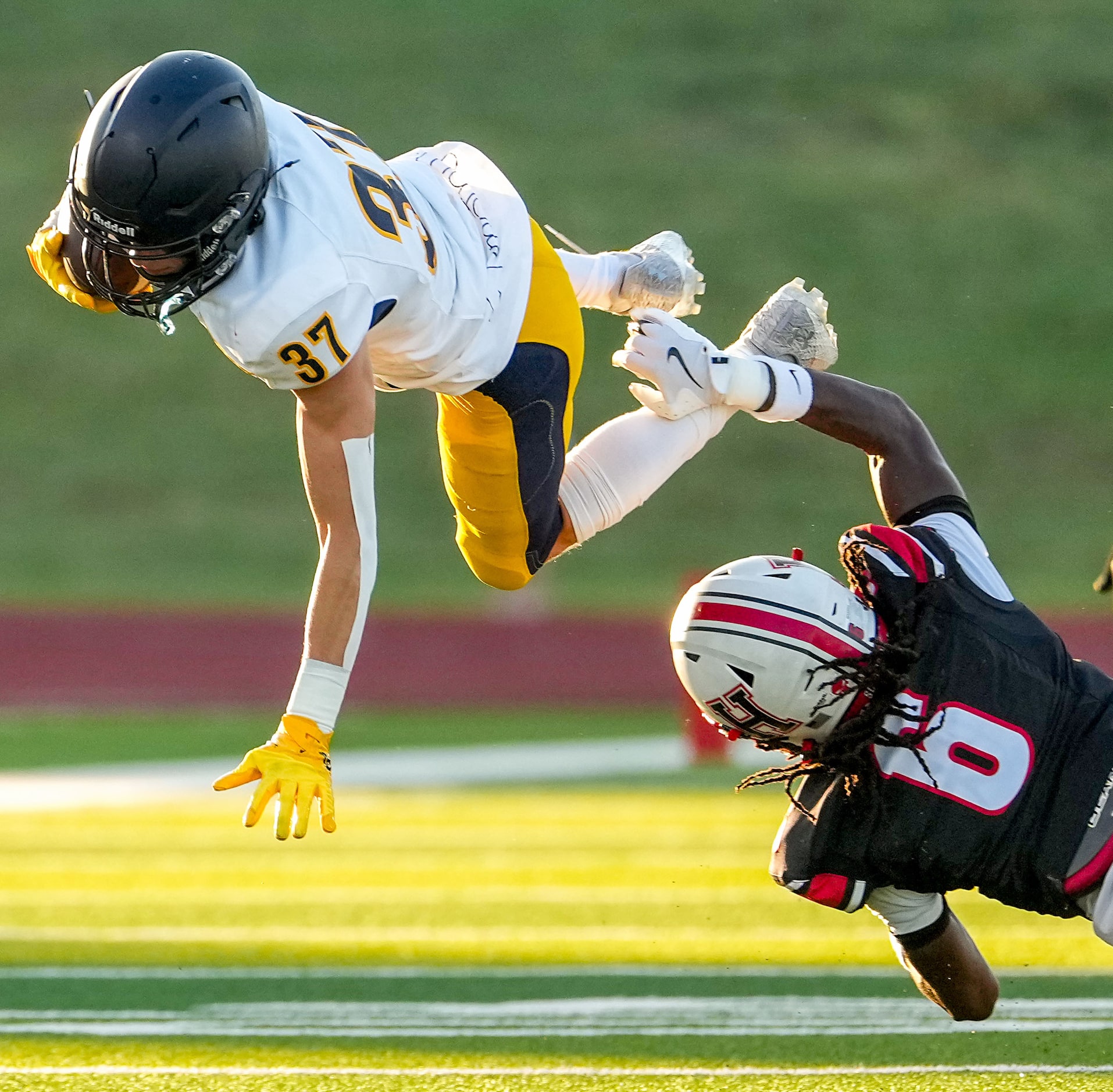 Highland Park wide receiver Cannon Bozman (37) is knocked off his feat by Rockwall-Heath...