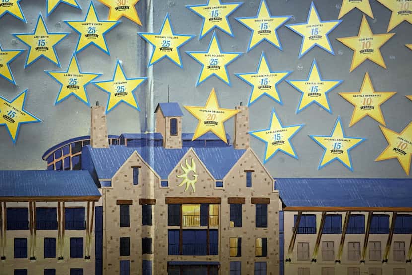 Stars recognizing employees for length of service hang on a mural of the Gaylord Texan...