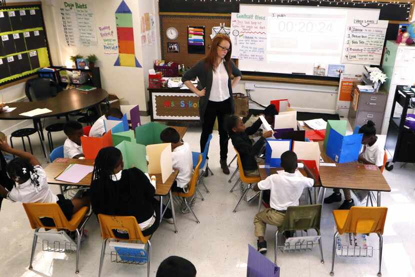 Katie Sokol administers a reading test to third-graders at George W Carver Creative Arts...