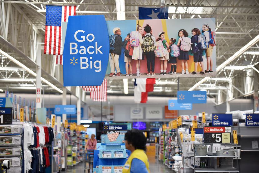Signage for back to school supplies are on display inside a Walmart Supercenter off of...