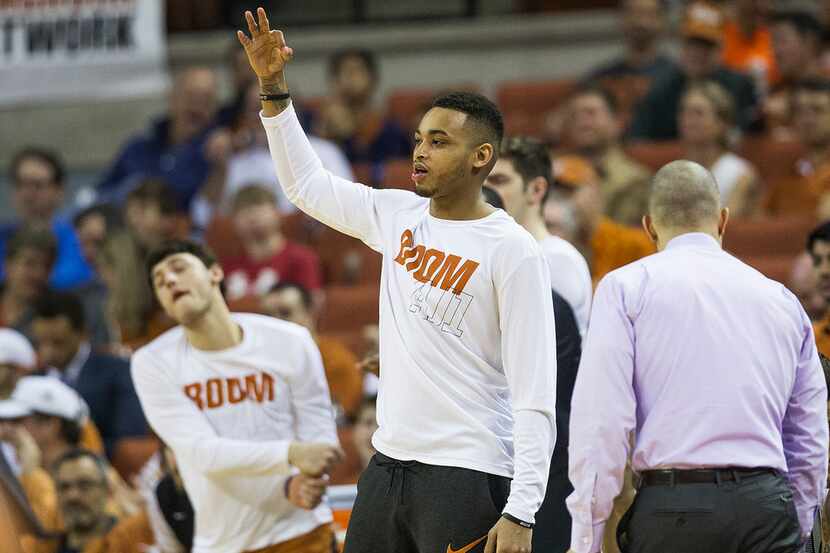Texas guard Eric Davis Jr. celebrates a teammate's three pointer during an NCAA college...