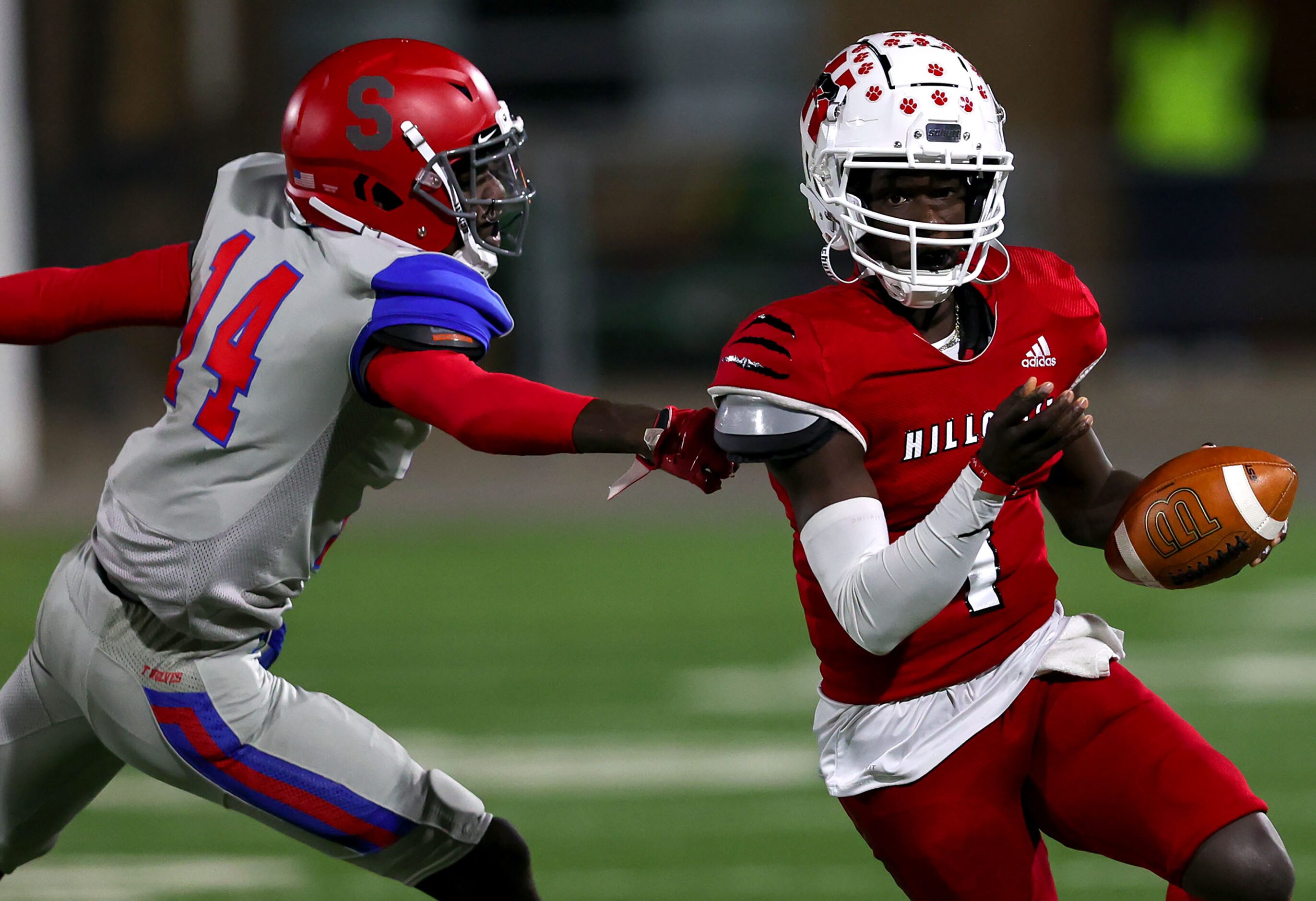 Hillcrest quarterbak Carter Sido (1) eludes Spruce linebacker Dexter Grant (14) for a big...