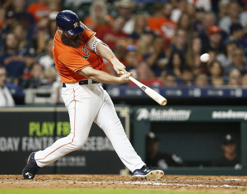 Evan Gattis of the Houston Astros hits a three-run home run in the eighth inning against the...